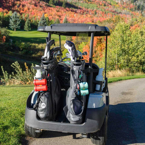 Golf cart with golf bags and equipment on a golf course during autumn.